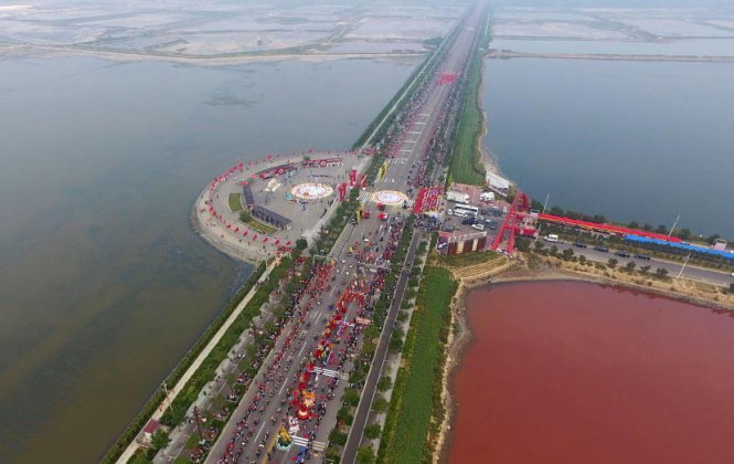 Hồ nước bị một con đường cắt ngang nên không bị đổi màu toàn bộ - Ảnh: CHINA DAILY