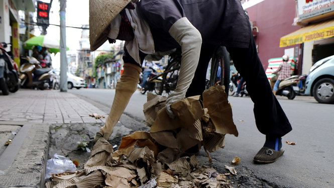 Giấy rác do người dân vứt lên miệng cống thoát nước trên đường Trần Huy Liệu - Ảnh: NGỌC DƯƠNG