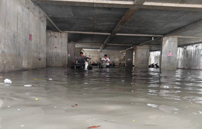 Xe máy chìm trong nước tại hầm giữ xe ở số 5D Nguyễn Siêu (Q.1, TP.HCM) - Ảnh: LÊ PHAN