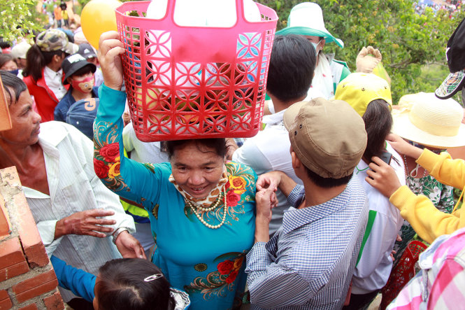 Một phụ nữ Chăm đội lễ vật lên tháp Pô Klong Garai để dâng lên các vị thần - Ảnh: TRUNG TÂN