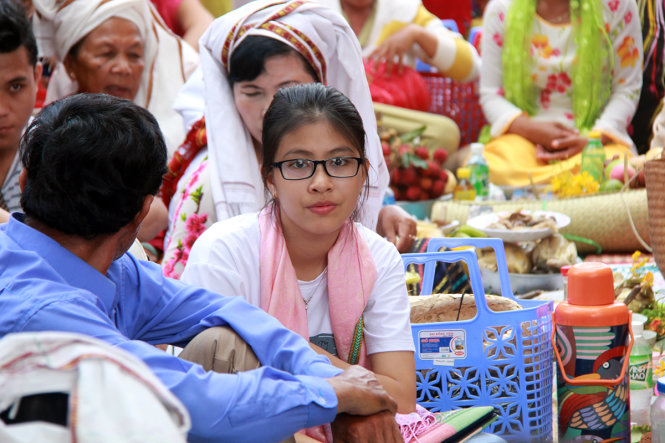 Một nữ du khách ngồi trò chuyện với các gia đình người Chăm đang dâng lễ ở tháp Pô Klong Garai - Ảnh: TRUNG TÂN