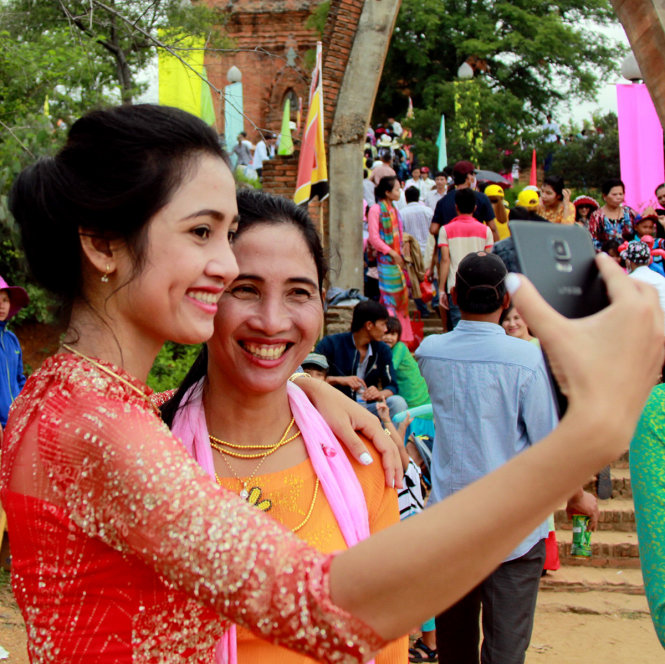 Hai mẹ con một thiếu nữ Chăm chụp hình kỷ niệm trước cổng tháp Pô Klong Garai - Ảnh: TRUNG TÂN