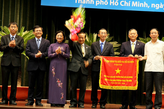 Bà Thân Thị Thư, trưởng ban tuyên giáo Thành ủy TP.HCM (thứ ba từ trái qua) tặng hoa cho lãnh đạo Học viện Cán bộ TP.HCM tại lễ khai giảng sáng 1-10. - Ảnh: TRẦN HUỲNH