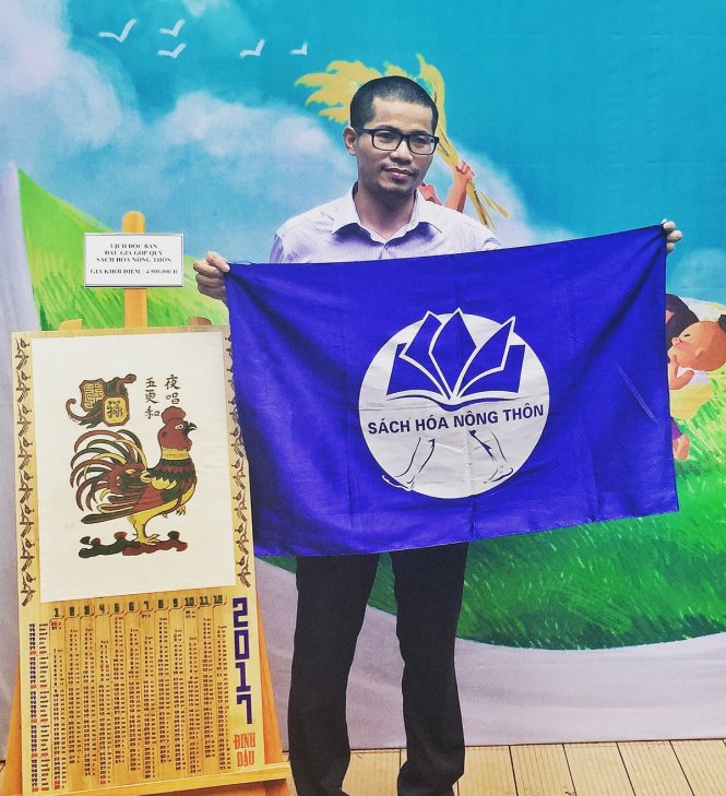Nguyễn Quang Thạch và lá cờ biểu tượng của dự án Sách hoá nông thôn của mình trong buổi giao lưu chiều 1-10 - Ảnh Minh Trang 