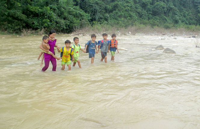Giáo viên đưa các em HS ở bản Vịn, xã Yên Thắng, huyện Lang Chánh (Thanh Hóa) vượt qua sông Âm để đến trường - Ảnh: HÀ ĐỒNG