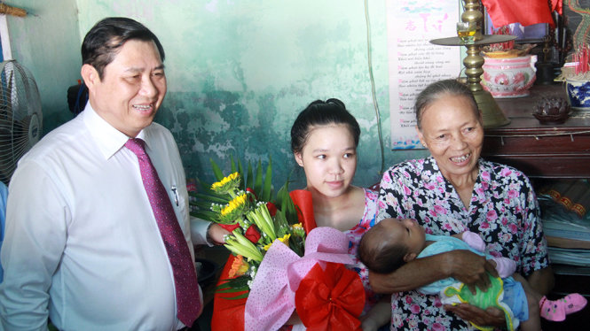 Ông Huỳnh Đức Thơ, chủ tịch UBND TP Đà Nẵng đến tận nhà trao giấy khai sinh cho trẻ em con của một cặp vợ chồng bị câm điếc - Ảnh: Hữu Khá