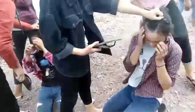 Nhóm nữ sinh dùng dép đánh vào mặt hai nữ sinh - Ảnh: D.HÒA cắt từ video clip