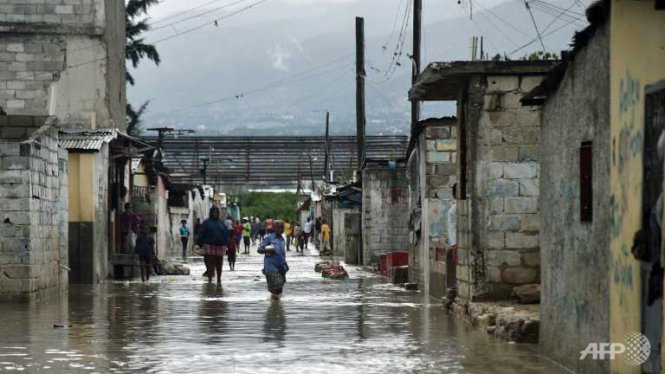 Người dân Haiti đi lại trên những con đường ngập nước tại thủ phủ Port-au-Prince, Haiti sau khi bão Matthew quét qua - Ảnh: AFP