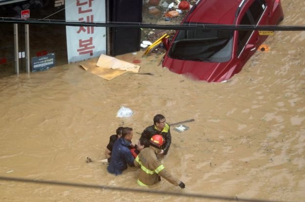 Lực lượng cứu hộ giải cứu người dân bị kẹt trong lũ - Ảnh: AP