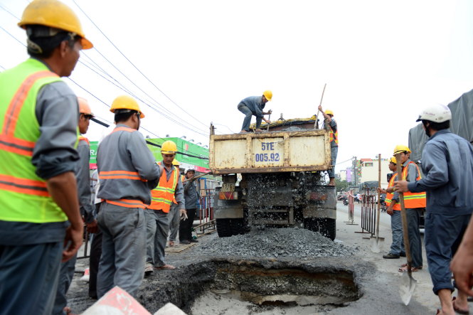 Nhân viên cầu đường khắc phục “hố tử thần” tại giao lộ Nguyễn Ảnh Thủ - Tô Ký, Q.12 (TP.HCM) sáng 3-10 - Ảnh: LÊ PHAN
