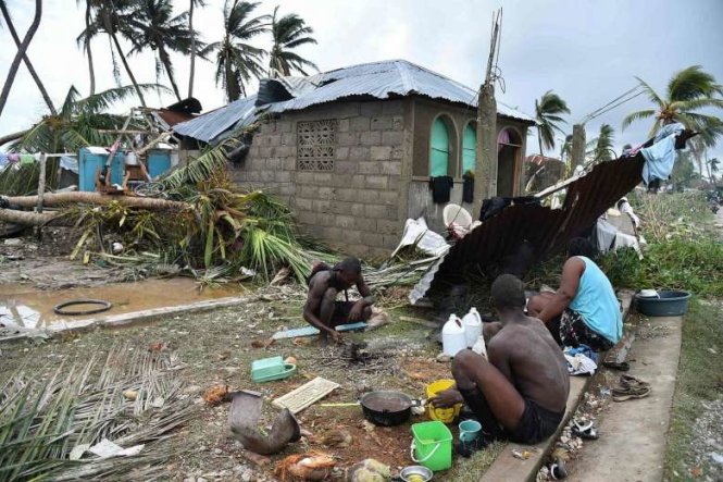 Một gia đình ở Croix Marche-a-Terre đang nấu nướng trước ngôi nhà bị bão phá hủy - Ảnh: REUTERS