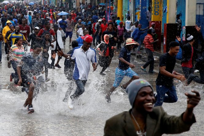 Người dân chạy dồn vào một điểm sơ tán trong lúc bão Matthew đổ vào vùng Port-au-Prince - Ảnh: Reuters