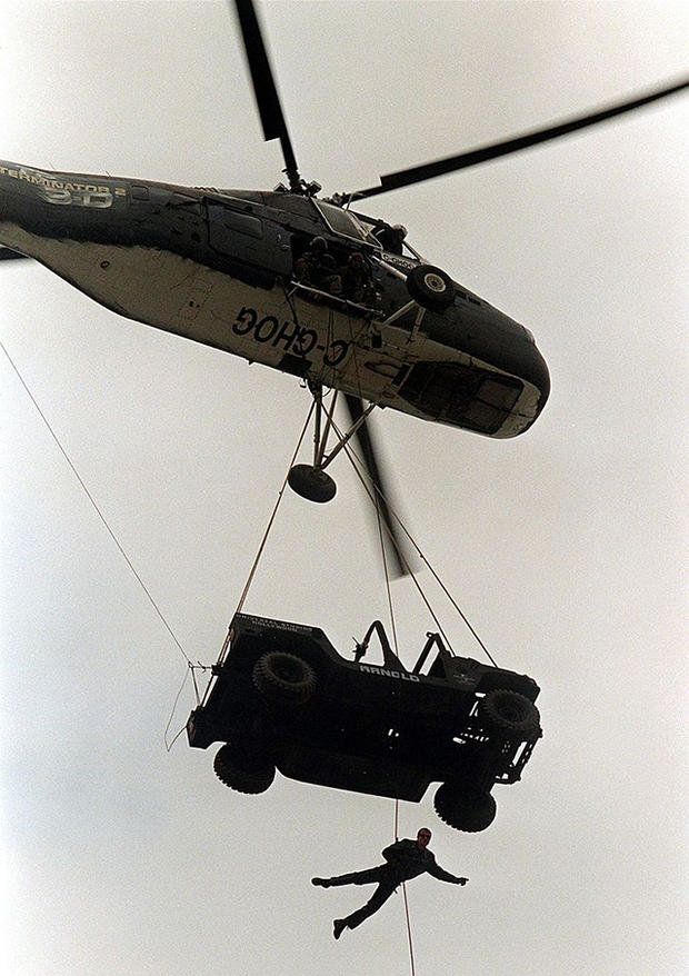 Một cascadeur treo mình vào chiếc xe Jeep do một trực thăng nâng lên trong một đoạn quảng cáo cho phim trường Universal Studios - Ảnh: Getty Images