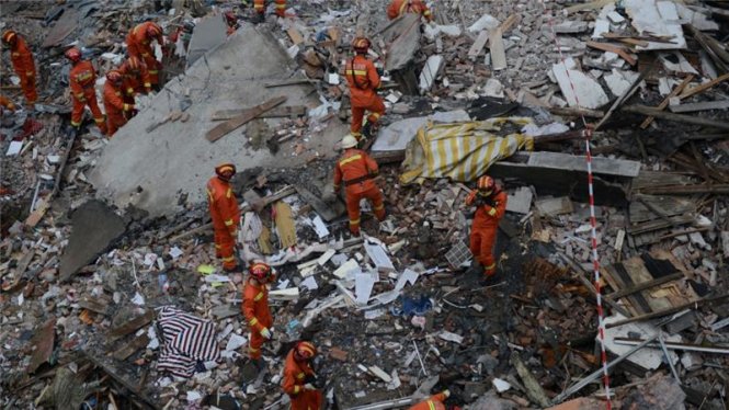 Lực lượng cứu hộ đang tìm kiếm những người còn mắc kẹt trong các đống đổ nát tại Ôn Châu - Ảnh: Reuters