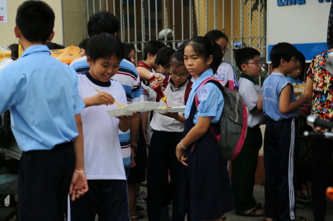 Học sinh tranh thủ ăn lót dạ trước khi vào lớp học thêm ở một trung tâm bồi dưỡng văn hóa tại TP.HCM - Ảnh: NHƯ HÙNG