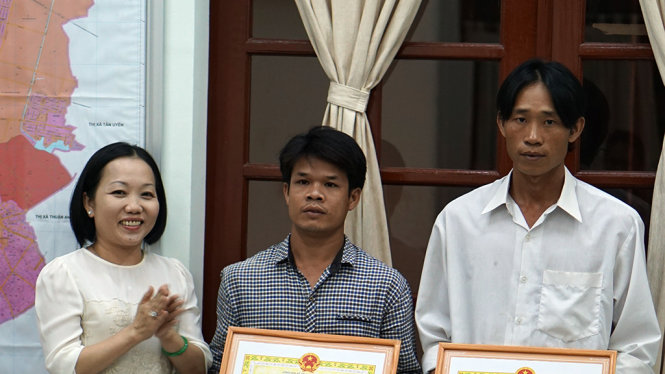 Bà Nguyễn Thu Cúc, Phó Chủ tịch UBND TP Thủ Dầu Một tặng giấy khen cho anh Đạt và anh Đang. - ẢNH: BÁ SƠN