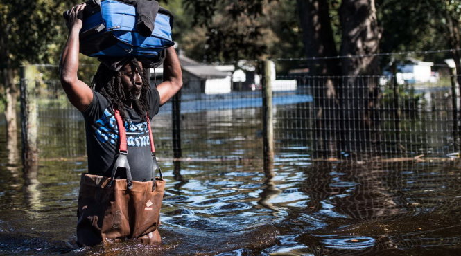 Một người đàn ông đang cố vượt qua một đường phố ngập nước ở Fair Bluff, Bắc Carolina hôm 11-10 (giờ địa phương) - Ảnh: Getty Images