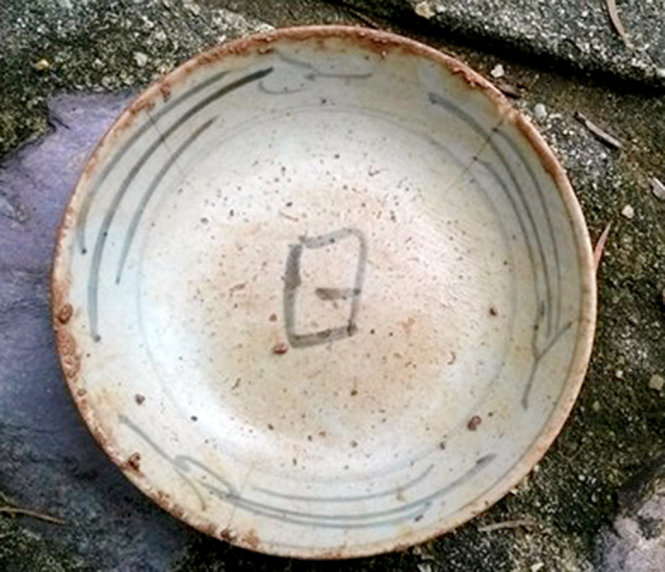 Chiếc bát có chữ “nhật” ở dưới đáy lòng, tìm thấy tại hố thăm dò trước chùa Vạn Phước - Ảnh: Nguyễn Văn Quảng