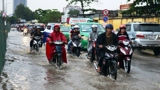 Triều cường khiến người dân đi trên đường Xa lộ Hà Nội (Q.2) gặp nhiều khó khăn
