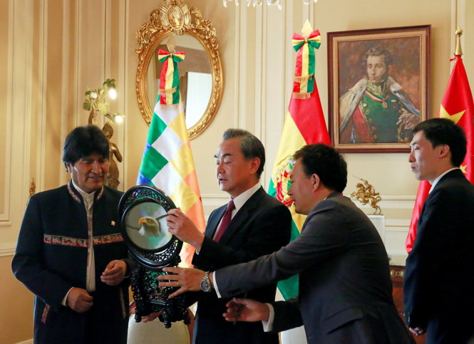 Bolivia's President Evo Morales (L) receives a gift from China's Foreign Minister Wang Yi (2nd L) at the presidential palace in La Paz, Bolivia October 6, 2016