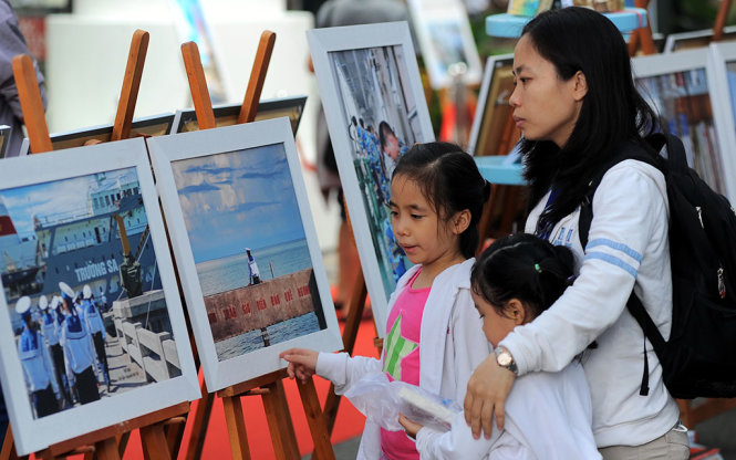 Người dân xem triển lãm tranh về Trường Sa của tác giả Nguyễn Mỹ Trà (phóng viên Đài tiếng nói VN) tại đường sách Nguyễn Văn Bình TP.HCM, sáng 15-10-2016 - Ảnh: TỰ TRUNG