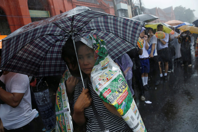 Người dân Thái Lan chờ viếng nhà vua trong cơn mưa ngày 16-10 - Ảnh: Reuters