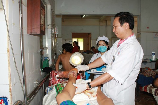 Các y bác sĩ tại Bệnh viện Đa khoa Đắk Lắk thăm khám, điều trị cho bệnh nhân Y Lâm sau khi bàn chân anh bị máy cắt cỏ xén lìa - Ảnh: B.D.