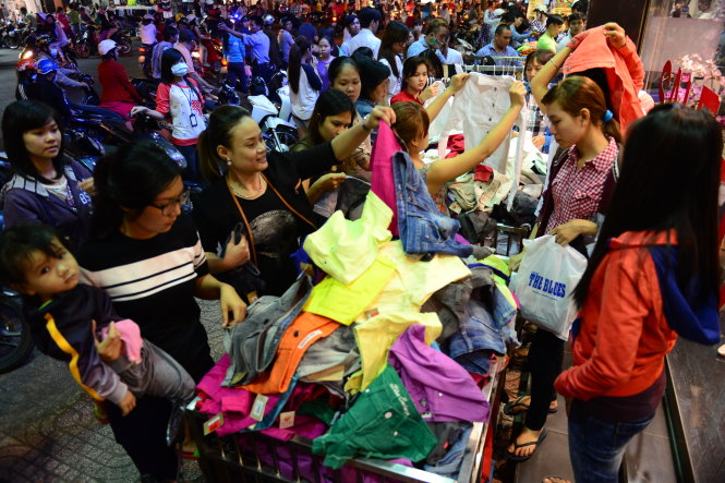 Khách mua sắm quần áo ở một cửa hàng quần áo tại góc đường Lý Chính Thắng và Hai Bà Trưng (Q.1, TP.HCM) - nơi để bảng giảm giá đến 70% - Ảnh: QUANG ĐỊNH