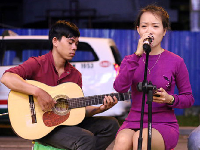 Hà Anh (phải) cùng bạn trai Nguyễn Phú Tài biểu diễn hát rong - Ảnh: NGỌC HIỂN
