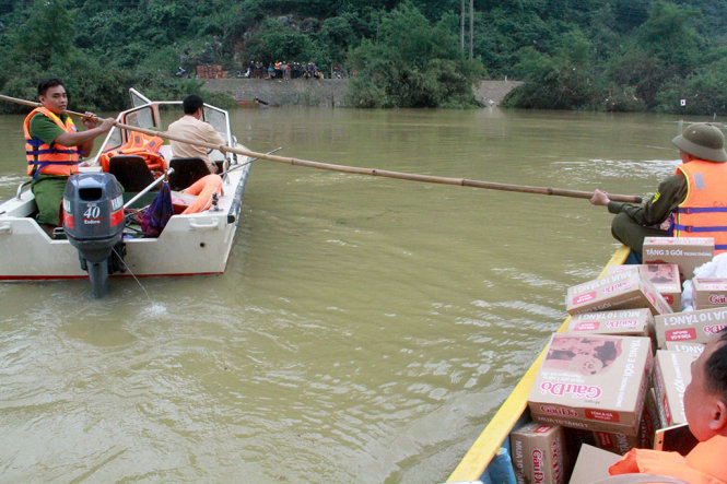 Hiện tuyến đường bộ vào Tân Hóa vẫn bị cô lập nên đoàn cứu trợ phải đợi rất nhiều giờ mới có thuyền vận chuyển hàng vào với người dân - Ảnh: HỮU KHÁ