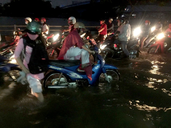 Người đi đường vật vã giữa biển nước ngập tại đường Trần Xuân Soạn - Ảnh: NGỌC KHẢI