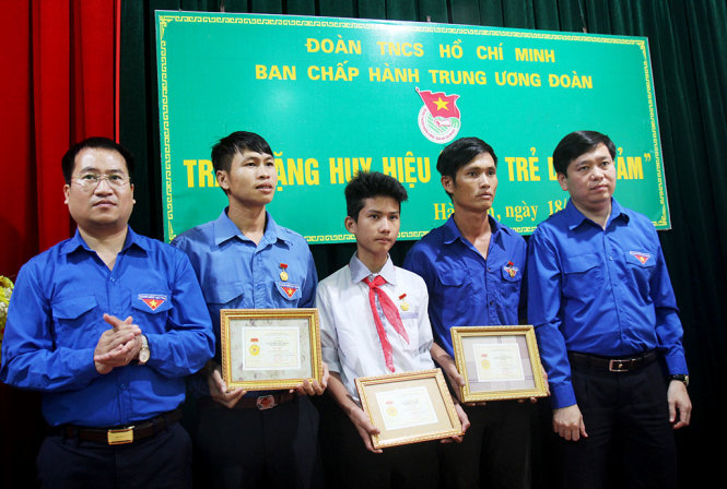 Anh Nguyễn Long Hải, bí thư TƯ Đoàn, chủ tịch Hội đồng đội TƯ trao huy hiệu “Tuổi trẻ dũng cảm” cho đoàn viên, thanh niên dũng cảm cứu người - Ảnh: DOÃN HÒA
