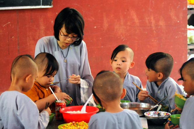 Trần Ngọc Anh Thư chăm cho các trẻ ăn trưa trong tịnh xá Bửu Sơn - Ảnh: A LỘC