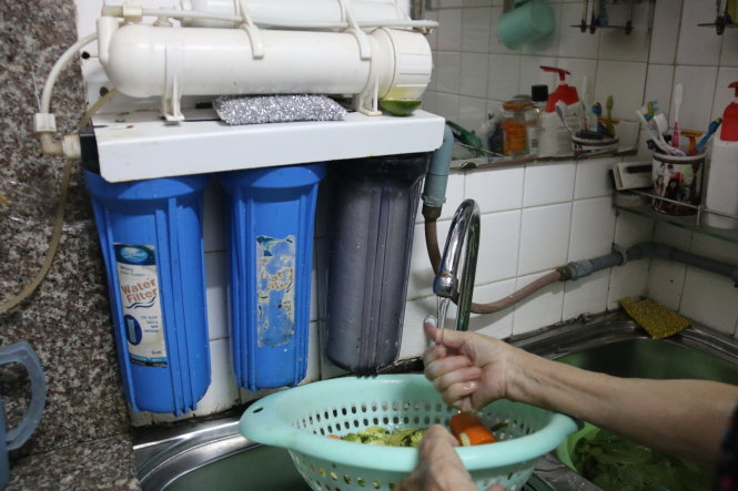 Nhiều hộ dân chung cư Tân Sơn Nhì 1 (Q.Tân Bình) phải lọc nước giếng để dùng - Ảnh: TIẾN LONG