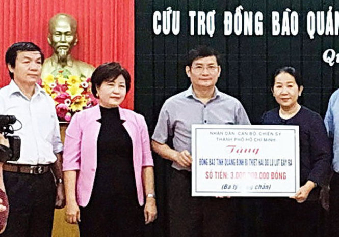 Ông Trần Tiến Dũng, phó chủ tịch UBND tỉnh Quảng Bình,  tiếp nhận tiền hỗ trợ từ đoàn công tác của TP.HCM - Ảnh M.HUYỀN