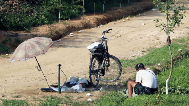 Người thợ sửa xe đạp ven đường ở tỉnh Bình An Nam -  Ảnh: THÁI LỘC