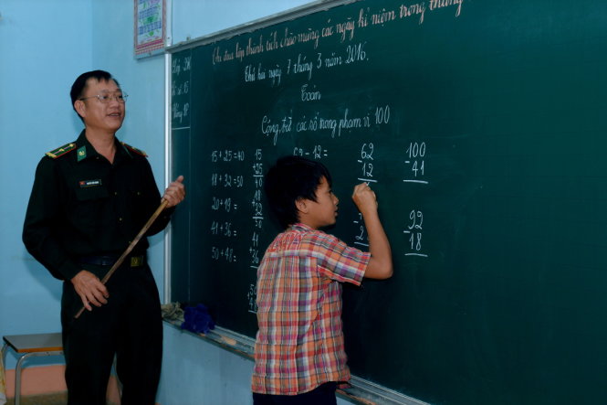 Thiếu tá Nguyễn Tiến Thanh dạy chữ cho học trò nghèo buôn Drang Phôk - Ảnh: B.D.