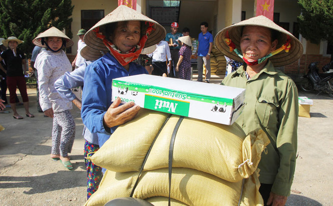 Hai người mẹ ở xã Đức Bồng, huyện Vũ Quang (Hà Tĩnh) đưa xe đạp đến cùng nhận quà cứu trợ - Ảnh: DOÃN HÒA