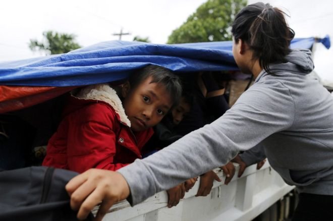 Trẻ em Philippines được chở bằng xe tải đi sơ tán - Ảnh: EPA
