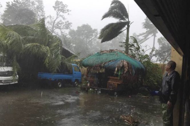 Một người đàn ông ở Ilocos Sur, miền bắc Philippines, tìm chỗ tránh mưa gió do ảnh hưởng bão Haima sáng 20-10 - Ảnh: AP