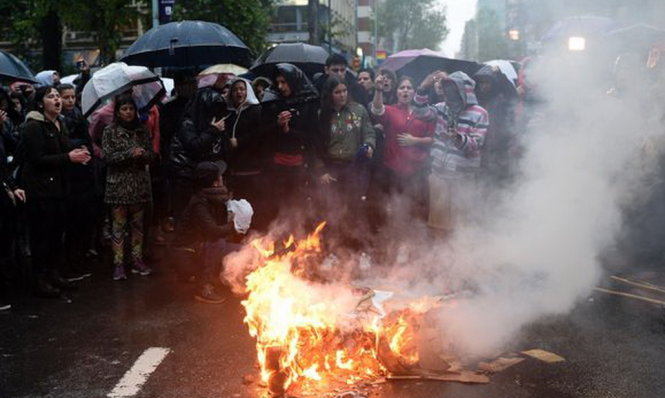 Người  biểu tình châm lửa đốt trên đường - Ảnh: AFP