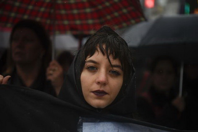 Người dân đội mưa biểu tình - Ảnh: AFP