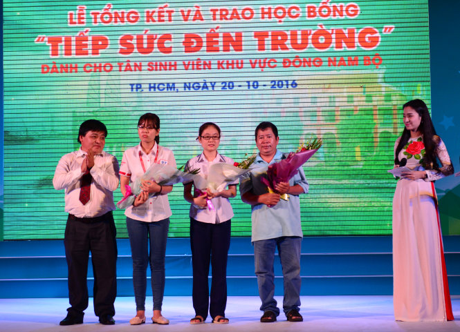 Ông Lê Thế Chữ, phó tổng biên tập báo Tuổi Trẻ, trao hoa cho các bạn sinh viên và phụ huynh tham gia giao lưu trong chương trình - Ảnh: Duyên Phan