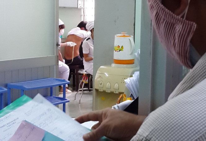Các bác sĩ hút dịch cho bệnh nhân bị tràn dịch màng phổi tại Bệnh viện Phạm Ngọc Thạch  - Ảnh: HỮU KHOA