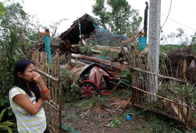 Một người phụ nữ đứng trước ngôi nhà bị hư hại hoàn toàn của chính mình sau khi bão Haima càng quét qua - Ảnh: Reuters