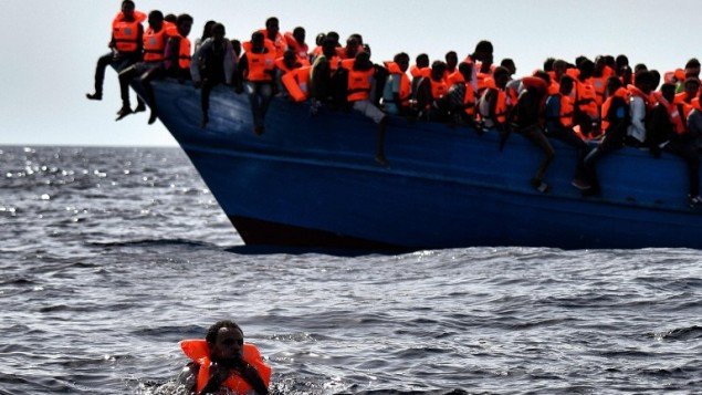 Người di cư chờ được cứu trong lúc bị trôi dạt trên Địa Trung Hải cách bở biển Libya khoảng 20 hải lý về phía bắc - Ảnh: AFP