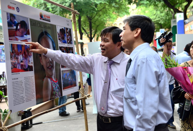 Ông Tăng Hữu Phong - Tổng biên tập báo Tuổi Trẻ  cùng các khách mời xem các tác phẩm trong buổi triển lãm “Việt Nam đất nước con người” - Ảnh: DUYÊN PHAN