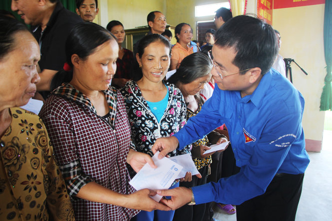 Anh Nguyễn Thế Hoàn, bí thư tỉnh Đoàn Hà Tĩnh trao quà cho người dân bị thiệt hại do mưa lũ, ngập lụt - Ảnh: DOÃN HÒA