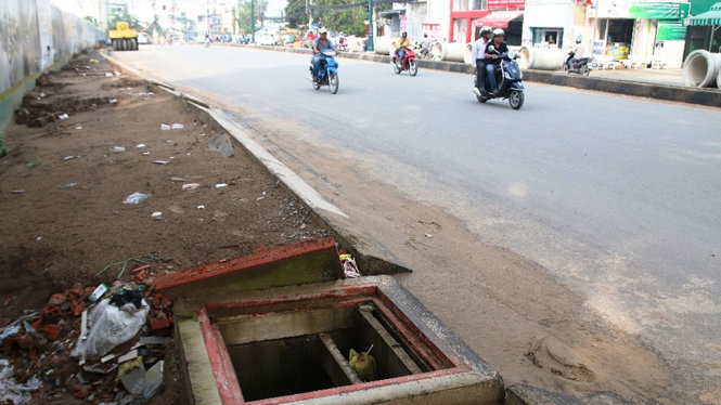Một hố ga mở nắp không đậy và không có rào cảnh báo tại đoạn đang thi công trên đường  Lê Văn Việt - Ảnh: LÊ PHAN