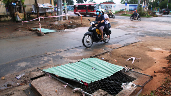 Hố ga trên đường Lê Văn Việt (Q.9) chỉ được đặt một tấm tôn che chắn chứ không có biển cảnh báo nguy hiểm - Ảnh: LÊ PHAN